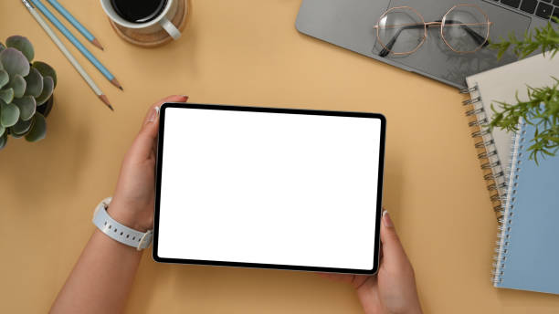 istock Comfortable workspace with office accessories and female holding tablet 1374117586