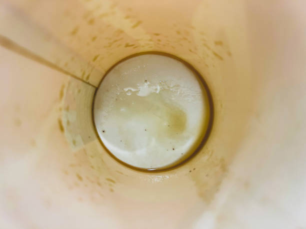 Pale lager beer overflowing in glass on yellow background