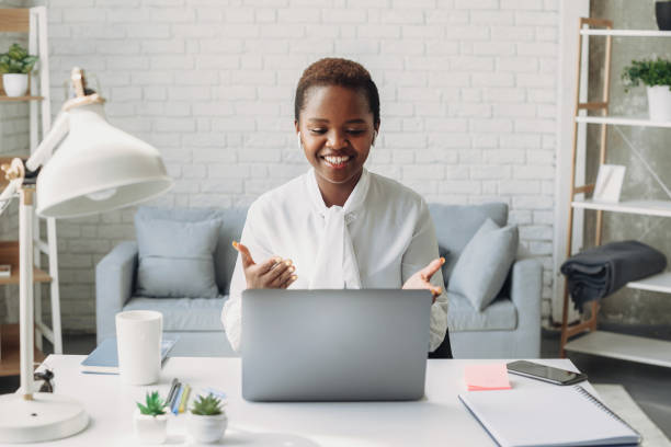 African american woman communicating distantly using video call application. Business intelligence. Smart office. Businesswoman portrait. Front view. African american woman communicating distantly using video call application. Business intelligence. Smart office. Businesswoman portrait. Front view. smart office stock pictures, royalty-free photos & images