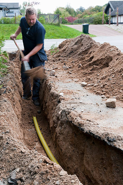 istock Electrician shoveling dirt in trench 137421007