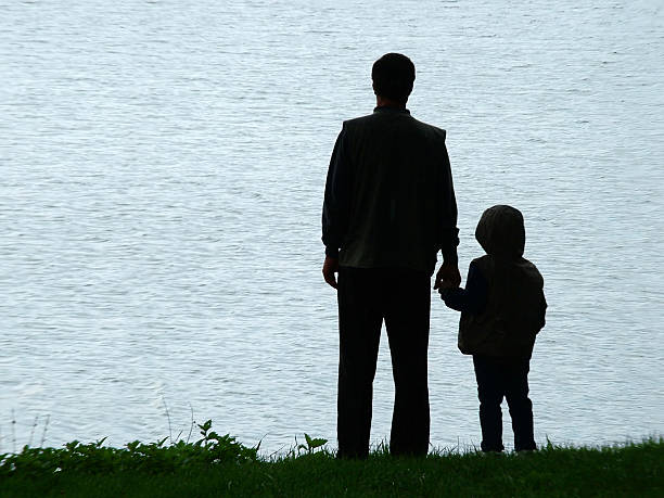 Man and child silhouette at evening stock photo