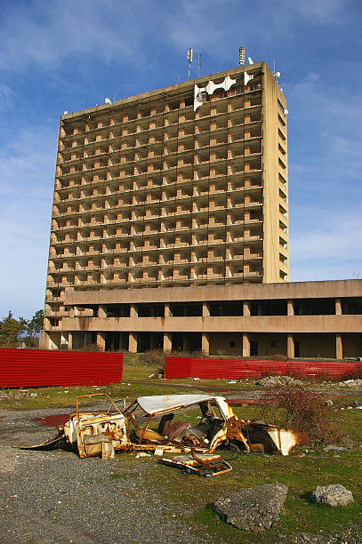 Abkhazia, war-ravaged spa-hotel and rusty obsolete car stock photo