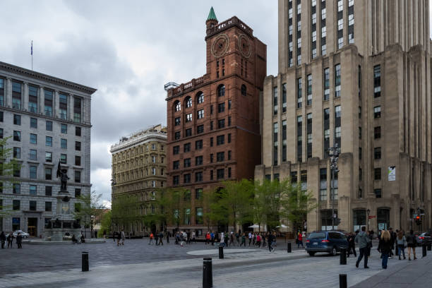 Architectural detail of the Place d'Armes, a square in Old Montreal, Quebec, Canada Montreal – May, 2017 – Architectural detail of the Place d'Armes, a square in Old Montreal quarter of the city. In the centre, the monument of Paul de Chomedey de Maisonneuve, founder of Montreal place darmes montreal stock pictures, royalty-free photos & images