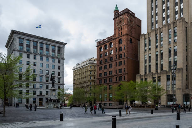 Architectural detail of the Place d'Armes, a square in Old Montreal, Quebec, Canada Montreal – May, 2017 – Architectural detail of the Place d'Armes, a square in Old Montreal quarter of the city. In the centre, the monument of Paul de Chomedey de Maisonneuve, founder of Montreal place darmes montreal stock pictures, royalty-free photos & images