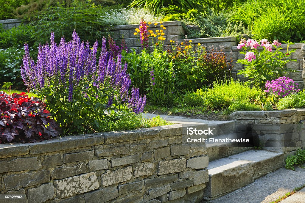Garden with stone landscaping Natural stone landscaping in home garden with steps and flowerbeds Yard - Grounds Stock Photo