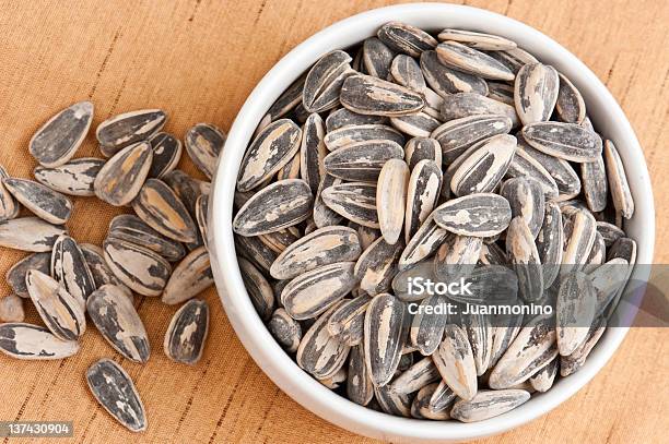 A Bowl Overflowing With Sunflower Seeds In The Shells Stock Photo - Download Image Now