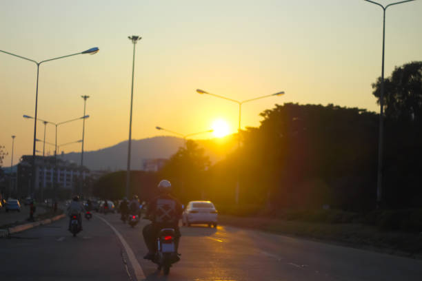 istock Blurred sunset over mountain with evening city traffic on road background 1374319225
