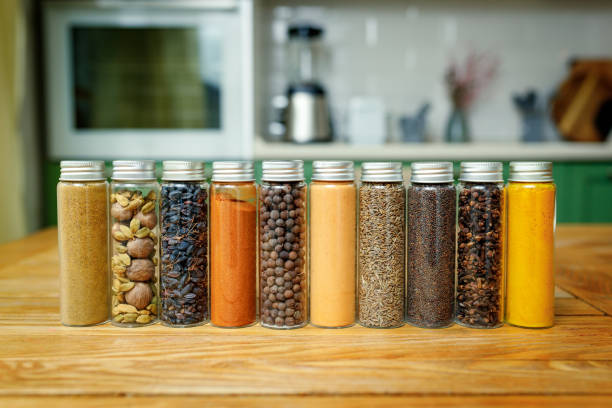 Different spices in glass flasks for spices on the table in home kitchen with copy space.