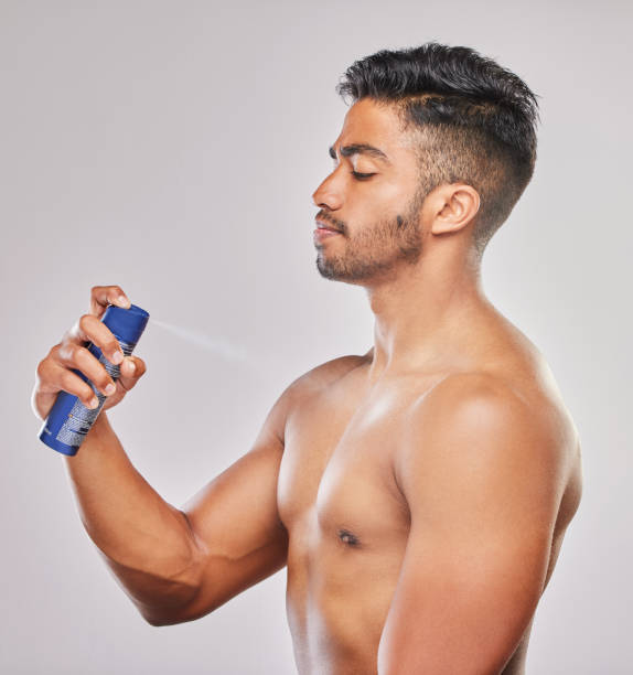 istock Shot of a young man applying deodorant against a grey background 1374366871