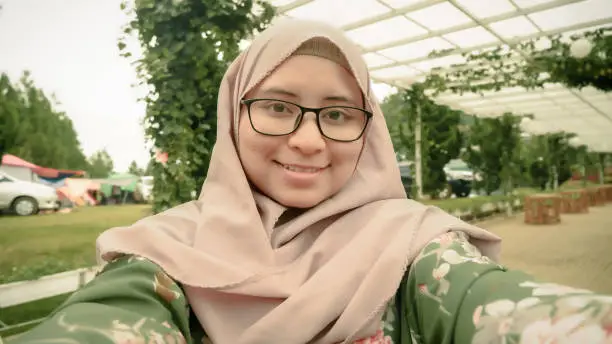 hijab woman from indonesia taking selfie in park