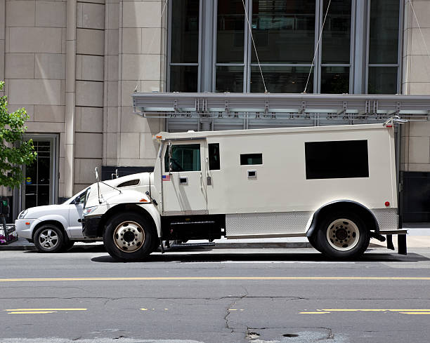 vista lateral armoured carro blindado estacionados na rua, no lado de fora do edifício - armored truck - fotografias e filmes do acervo