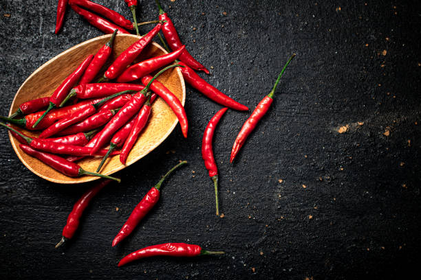istock Chili peppers on a wooden plate. 1374414258