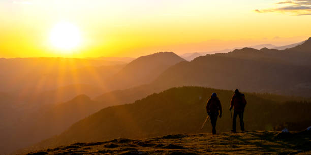 istock Hikers walking on grassy hill 1374414775