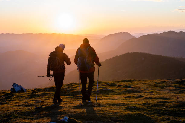 istock Hikers walking on grassy hill 1374414805