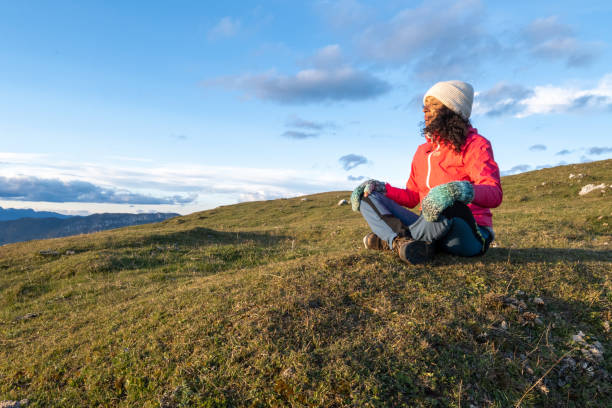 istock Women sitting on grassy hill 1374414836
