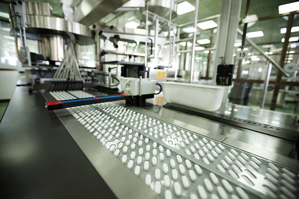 tablet packing in pharmaceutical company - farmaceutische fabriek stockfoto's en -beelden