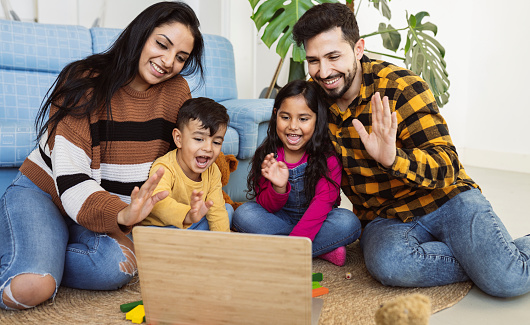 Hispanic family, in living room of house carpet with laptop video call