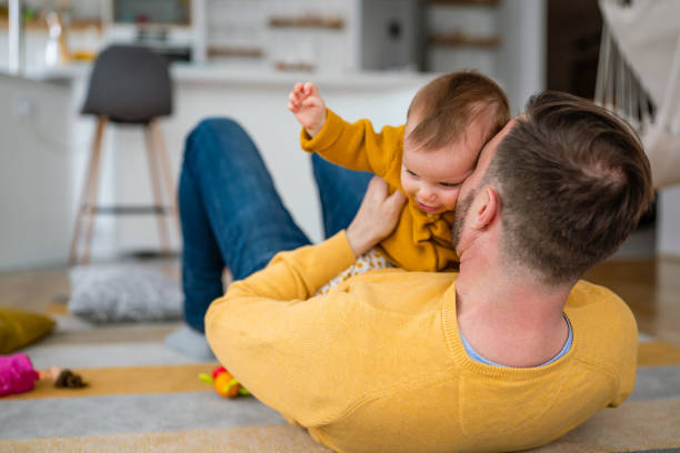 istock Happy young father playing with little daughter at home 1374451987