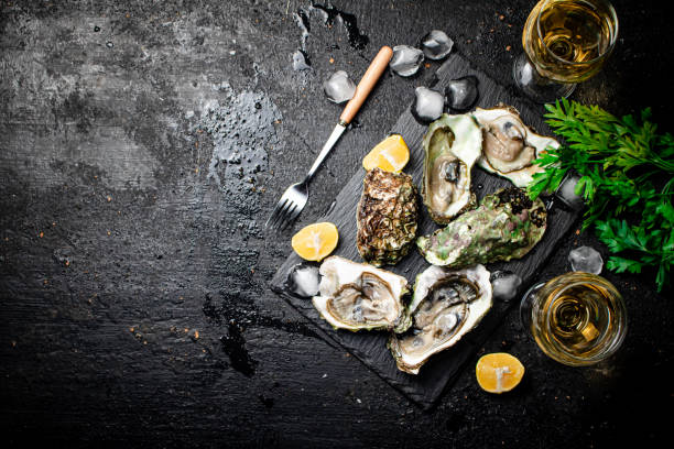 istock Fresh oysters with greens. On a black background. 1374452761