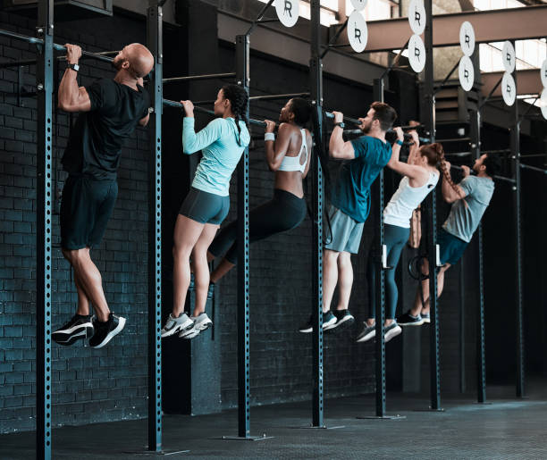 Shot of a group of people completing pull ups together Strong arms won't build themselves cross training stock pictures, royalty-free photos & images