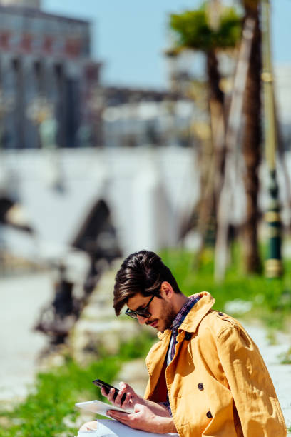 Elegant manager holding tablet and mobile on beautiful spring day