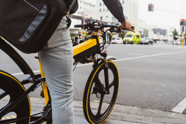 personne attendant le signal tout en conduisant sur un vélo électrique. - electric bicycle photos et images de collection