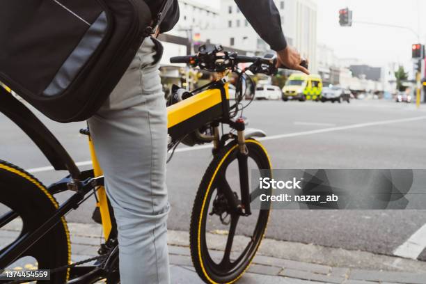 Person Waiting On Signal While Riding On Ebike Stock Photo - Download Image Now - Electric Bicycle, New Zealand, City