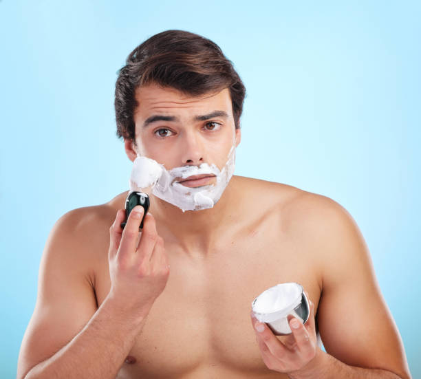 istock Shot of a young man applying shaving foam against a studio background 1374454561
