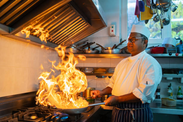 A chef is broiling an Indian curry stock photo