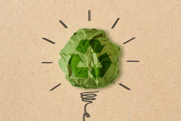 くしゃくしゃになったリサイクル紙にリサイクルサインを入れた電球描画 - エコロジーとリサイクルの概念 - recycled bulb ストックフォトと画像