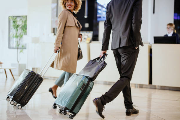 Unrecognisable business people arriving at the hotel with suitcases and bags Business travellers with suitcases walking towards reception business journey stock pictures, royalty-free photos & images