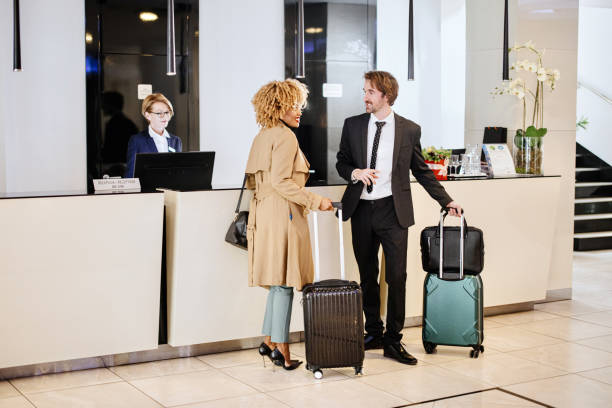 istock Multi-ethnic business couple arriving at hotel reception desk 1374471993