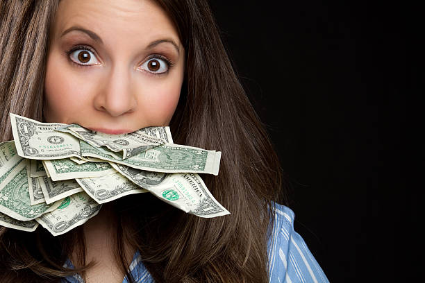 Woman With Money in Mouth stock photo