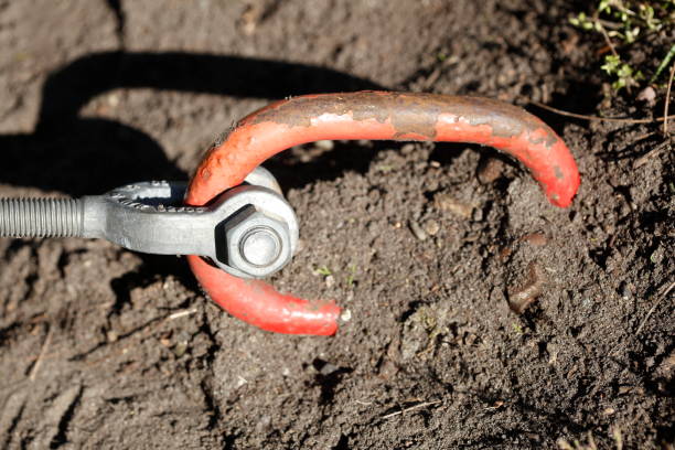 red carabiner hook anchored in the earth red snap hook anchored in the ground erde stock pictures, royalty-free photos & images