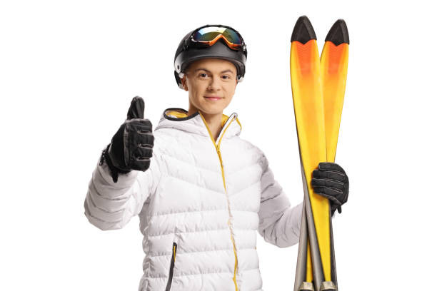 Guy with ski goggles and jacket holding a pair of skiis and gesturing thumbs up Guy with ski goggles and jacket holding a pair of skiis and gesturing thumbs up isolated on white background thumbs up for skiing stock pictures, royalty-free photos & images
