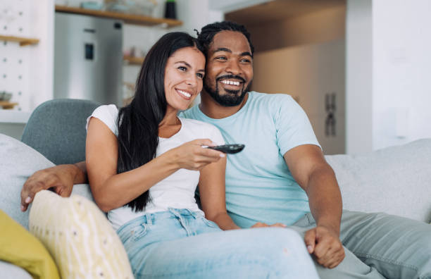 istock Cute young couple cuddling while watching tv. 1374502364