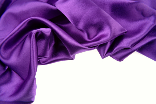 Closeup of purple silk fabric on white background