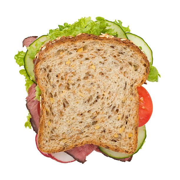 Roast beef sandwich top view, isolated on white Multi-grain roast beef sandwich with lettuce, tomatoes, cucumbers and radishes, viewed from the top, with a clipping path sandwich stock pictures, royalty-free photos & images