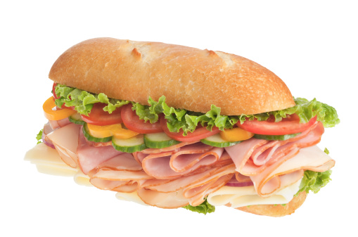 Large sandwich loaded with fresh veggies, cheese, ham, and sliced turkey breast