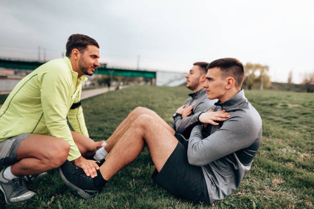 istock friends doing abs together at the park 1374518332