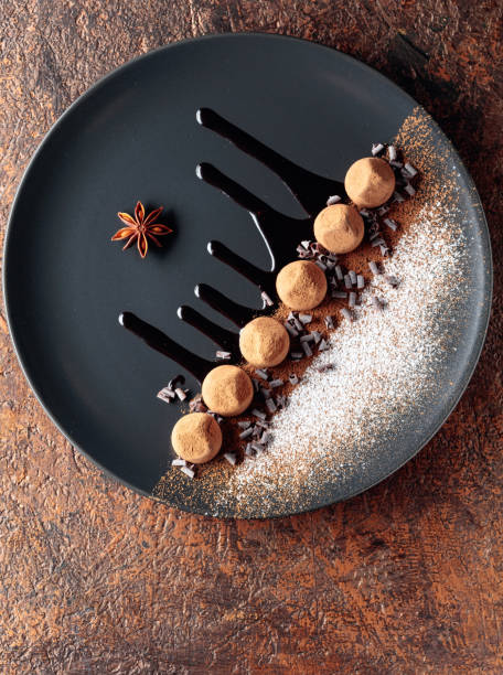 istock Chocolate truffles on a black plate with chocolate sauce. 1374518453