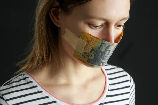 お金は沈黙を買う。女性の口は豪ドル紙幣で覆われていた�。腐敗と言論の自由の概念。 - currency silence censorship behavior ストックフォトと画像