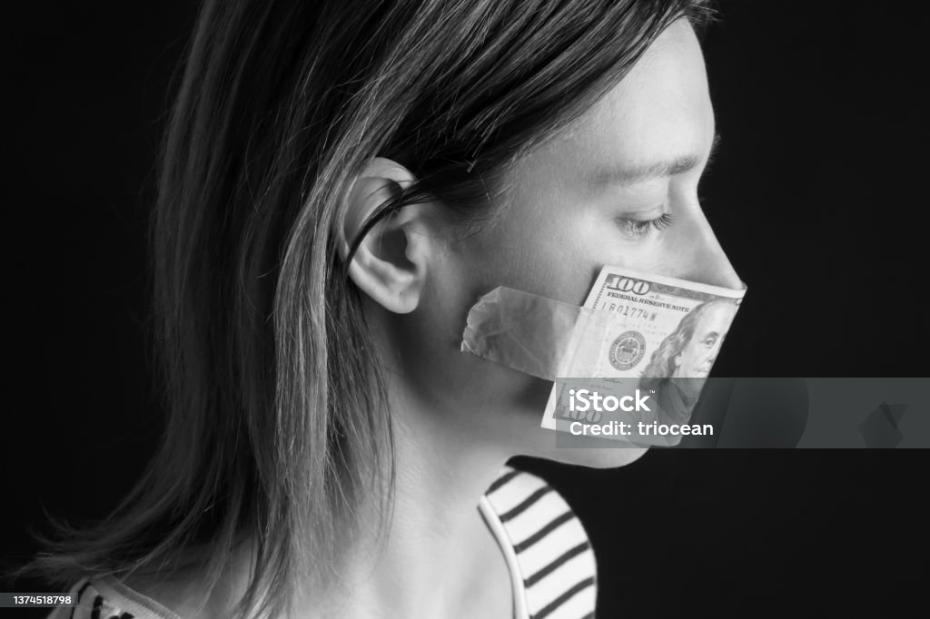 Money buys silence. Woman's mouth covered with dollar bill. Corruption and freedom of speech concept. 35-39 Years Stock Photo