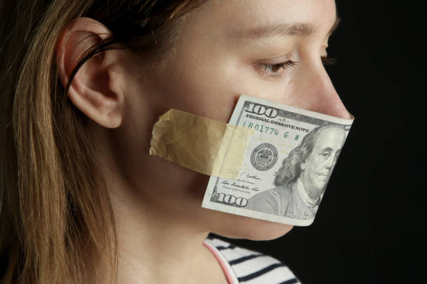 お金は沈黙を買う。女性の口はドル紙幣で覆われてい�た。腐敗と言論の自由概念。 - currency silence censorship behavior ストックフォトと画像