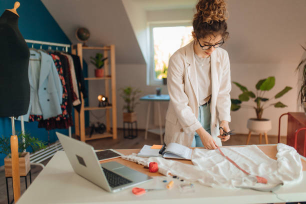 Young fashion designer working in her atelier stock photo