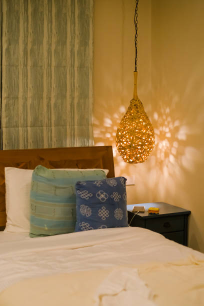 istock Lamp with orange light on bed and pillow in home room 1374545671