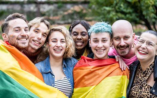 Grupo de jóvenes activistas por los derechos lgbt con bandera arcoíris, personas diversas de la comunidad gay y lesbiana photo