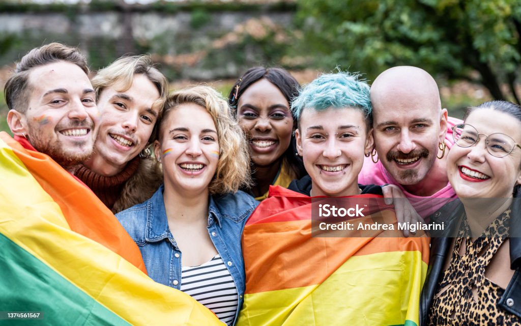 Group of young activist for lgbt rights with rainbow flag, diverse people of gay and lesbian community LGBTQIA Rights Stock Photo