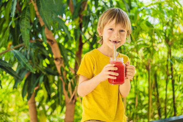 istock Boy holding Healthy watermelon smoothie in Mason jar 1374573264