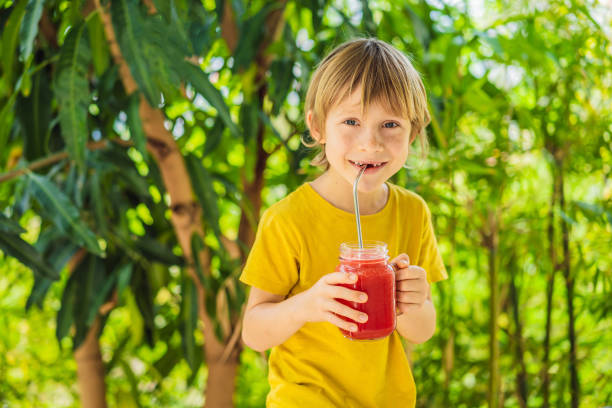 istock Boy holding Healthy watermelon smoothie in Mason jar 1374573266